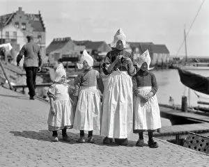 Fishing Village Prints: 1920s 4 DUTCH MAIDS WEARING CAPS TYPICAL OF VILLAGE OF VOLENDAM WITH WHITE APRONS AND WOODEN SHOES ON DOCKS OF