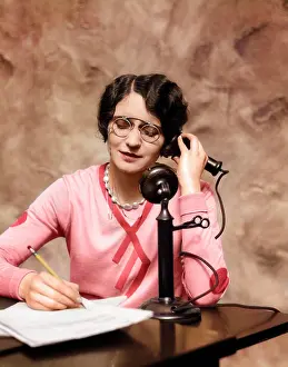 Industry Prints: 1920s WOMAN WEARING PINCE-NEZ GLASSES SITTING AT DESK TALKING ON CANDLESTICK PHONE AND WRITING