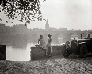 Autos Prints: 1920s TWO YOUNG WOMEN WITH ANTIQUE AUTOMOBILE SITTING STANDING TOGETHER TALKING BY STONE WALL LOIRE RIVER VALLEY FRANCE