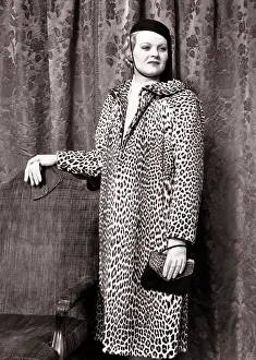 1938 Prints: 1930s 1938 FASHIONABLE WOMAN WEARING LEOPARD SKIN COAT STANDING BY CHAIR HOLDING ALLIGATOR HAND BAG WEARING LEATHER