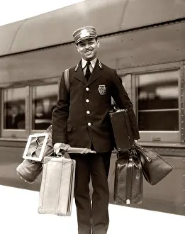 Uniform Prints: 1930S 1940S Portrait Smiling African American Man Red Cap Porter Carrying Luggage Bags Suitcases Passenger Railroad