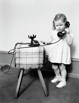 1 2 Years Prints: 1930S 1940S Unhappy Frowing Little Girl Takling On Old Black Rotary Dial Telephone