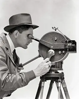 Portable Prints: 1930s PORTRAIT PROFILE MAN CINEMATOGRAPHER OPERATING AKELEY HAND CRANK PORTABLE 35 MM FILM MOVIE CAMERA MOUNTED ON
