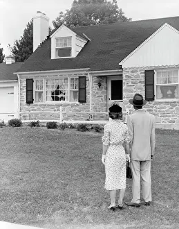 Story Prints: 1940S 1950S Couple Standing Outside Looking At Stone Suburban House