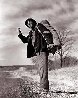 Main Road Prints: 1940s 1950s UNEMPLOYED MAN A HOBO CALLED A BINDLESTIFF CARRYING A BINDLE OVER HIS SHOULDER HITCHHIKING ON RURAL HIGHWAY