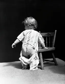 Nude Prints: 1940S Baby Wearing Drop Seat Pajamas Showing Bare Bottom Leaning On Chair