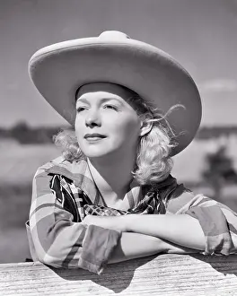 Dreams Prints: 1940s BLONDE COWGIRL WEARING BIG BRIMMED COWBOY HAT LEANING ON FENCE WEARING PLAID SHIRT BANDANA THOUGHTFUL FACIAL