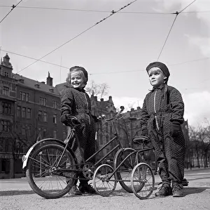 Bicycle Prints: 1940s children. Two children are outside with their bicycles