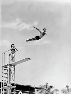 Leaping Prints: 1940S Man Swan Diving Off High Diving Board Woman Watching