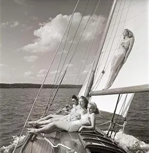 Grownups Prints: 1940s sailing boat. Four young women are aboard the sailing boat and enjoying the sunshine on deck