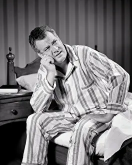 Expressions Prints: 1940s SLEEPLESS MATURE MAN WEARING STRIPED PAJAMAS SITTING ON EDGE OF BED WITH FRUSTRATED TIRED FACIAL EXPRESSION