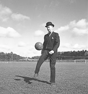 Suit Prints: 1940s soccer player. A gentleman dressed in a suit and a bowler hat is kicking a football in the air