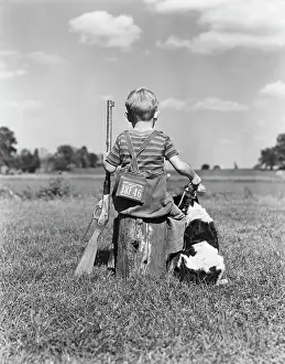 Oldtime Prints: 1940s BACK VIEW OF BOY WEARING HUNTING PERMIT HOLDING BB GUN SITTING ON TREE STUMP NEXT TO SPRINGER SPANIEL DOG