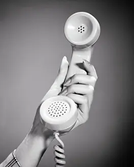 Communications Prints: 1950s 1960s 1970s WOMAN HAND HOLDING CLASSIC TELEPHONE COMMUNICATIONS HANDSET FOR LISTENING AND SPEAKING