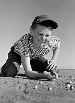 Tooth Prints: 1950S 1960S Boy Playing Marbles Kneeling In The Dirt Squinting Missing A Front Tooth