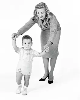 Sons Prints: 1950s 1960s CONCERNED PROUD MOTHER WATCHING HELPING BABY BOY TAKING FIRST STEPS WALKING LOOKING AT CAMERA