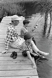 Small Group Of People Prints: 1950S 1960S Father With Two Sons Sitting On Dock Fishing Together Outdoor By Pond