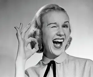 Exciting Prints: 1950S Blond Woman Winking Eye And Making Ok Sign With Thumb And Finger