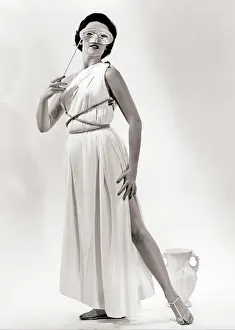 Styles Prints: 1950s BRUNETTE WOMAN WEARING LONG WHITE GRECIAN DRESS COSTUME HOLDING MASK TO EYES LOOKING AT CAMERA