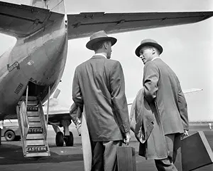 Doors Prints: 1950s TWO BUSINESSMEN TALKING ON TARMAC ABOUT TO ENTER REAR DOORS OF EASTERN AIRLINES PASSENGER PLANE