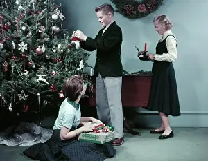 1950s Prints: 1950S Two Girls And One Boy Decorating Christmas Tree With Ornaments Teens Teenagers Holiday