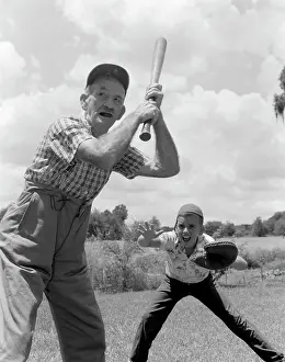 Determined Prints: 1950S Grandfather At Bat With Boy As Catcher
