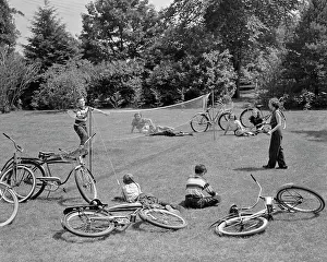 Bicycle Prints: 1950s GROUP OF TEENS LYING IN GRASS WITH BICYCLES BOY GIRL PLAYING BADMINTON