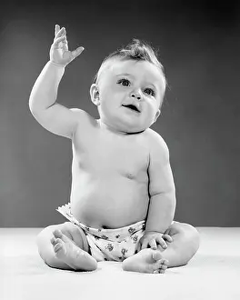 Raised Prints: 1950S Portrait Of Baby Sitting One Arm Raised Indoor