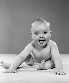 1950S Portrait Of Baby Sitting And Sticking Tongue Out Indoor