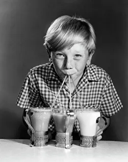Cafeteria Prints: 1950S Portrait Of Blonde Boy Drinking From Straws Of 3 Milkshakes Sodas