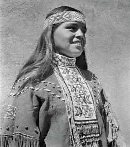 Indians Prints: 1950s PORTRAIT SMILING NATIVE AMERICAN INDIAN WOMAN WEARING BEADED HEADBAND COLLAR NECKPIECE AND BUCKSKIN DRESS