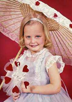 Oldtime Prints: 1950s SMILING LITTLE BLOND GIRL LOOKING AT CAMERA WITH VALENTINE BOUQUET OF RED HEARTS AND FLOWERS UNDER LACY PARASOL