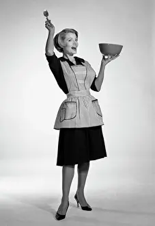 People Adults Prints: 1950S Woman In Apron Holding Mixing Bowl And Spoon Exaggerated Expression