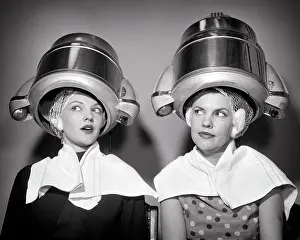 Networking Prints: 1950s TWO WOMEN SITTING UNDER BEAUTY SALON HAIR DRYERS WEARING HAIRNETS TOWELS TALKING GOSSIP
