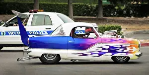 Blur Prints: 1956 Nash Metropolitan custom dragster driving by police car