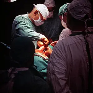 Doctors Prints: 1960s 1970s ANONYMOUS TEAM OF LEAD SURGEON ASSISTANT SURGEONS AND NURSES IN MASKS AND GLOVED HANDS PERFORMING A MEDICAL