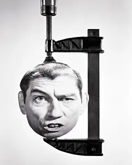 Expressions Prints: 1960S 1970S MANS HEAD WITH FUNNY FACIAL EXPRESSION BEING SQUASHED IN A WOODWORKING CLAMP