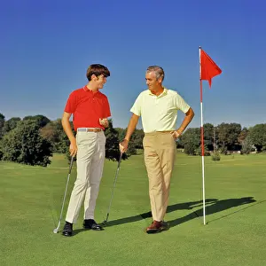 Oldtime Prints: 1960s 1970s TEENAGE BOY AND MIDDLEAGED FATHER ON GOLF COURSE GREEN LEANING ON CLUBS TALKING