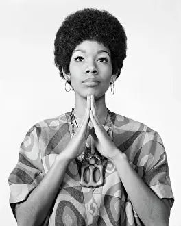 Community Prints: 1960s AFRICAN AMERICAN WOMAN AFRO HAIRDO LOOKING AT CAMERA ARMS FOLDED IN PRAYER MEDITATION WEARING HOOP EARRINGS PRINT