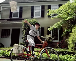 Oldtime Prints: 1960s BOY IN BASEBALL UNIFORM RIDING BICYCLE DELIVERING NEWSPAPERS