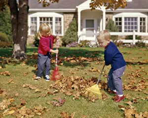 Oldtime Prints: 1960s BOY GIRL RAKING AUTUMN LEAVES IN YARD SUBURBAN HOUSE IN BACKGROUND