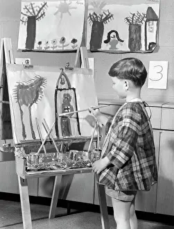 Easel Prints: 1960S Boy In Smock Painting At Easel In Art Class