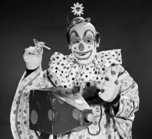 Circus Prints: 1960S Clown In Polka-Dotted Outfit Taking Picture With Old-Time Camera Holding Birdie In Opposite Hand
