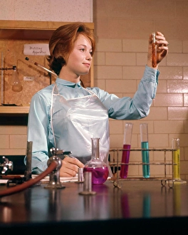 Sciences Prints: 1960s COED FEMALE STUDENT CHEMISTRY LAB LABORATORY LOOKING AT TEST TUBE SCIENCE EDUCATION