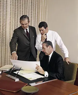 Paperwork Prints: 1960s THREE EXECUTIVE MEN MEETING DISCUSSING PAPERWORK PLANS