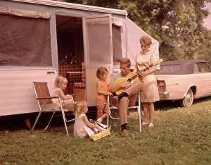 Dads Prints: 1960s FAMILY OUTING CAMPING TRAILER FATHER PLAYING GUITAR MOTHER AND THREE DAUGHTERS LISTENING