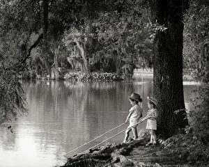 Hats Prints: 1960s LITTLE BOY AND GIRL FISHING HOLDING STICKS IN WATER BAYOU VEGETATION SPANISH MOSS HANGING FROM TREES