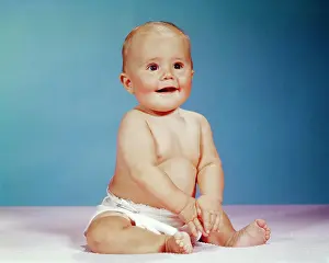 Nappy Prints: 1960s PORTRAIT OF SMILING BABY GIRL SITTING UPRIGHT WEARING CLOTH DIAPER