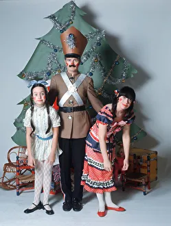 Story Prints: 1960s STUDIO SETTING OF FAMILY DRESSED AS CHRISTMAS NUTCRACKER DOLL CHARACTERS LOOKING AT CAMERA CHRISTMAS TREE IN