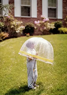 Brick Prints: 1970s 1980s LITTLE BOY UNDER PLASTIC TRNSPARENT BUBBLE UMBRELLA RHODODENDRON BRICK HOUSE SPRING RAIN SHOWER OUTDOOR